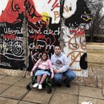 Izabella Uccello travels the EU with a stop in front of a section of the Berlin Wall.