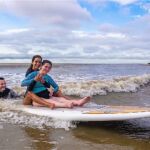 Kayla (center) enjoys a day of adaptive surfing with Waves of Impact in Galveston, Texas.