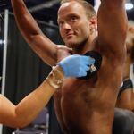 Wheelchair bodybuilder Tyler Brey gets tan applied prior to taking the stage at the 2019 Mr. Olympia in Las Vegas, Nev. (Photo by Christopher DiVirgilio/SNS).