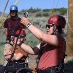 National Ability Center staff member Elisa Banyard demonstrates how to use climbing gear during the 2021 Submerged Festival's Climbing Challenge event in Park City, Utah. (Photo by Christopher Di Virgilio).