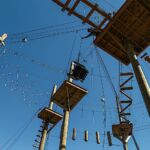 A manual wheelchair is lifted onto the main platform at the climbing challenge course at the National Ability Center in Park City, Utah during the 2021 Submerged Festival. (Photo by Christopher Di Virgilio).